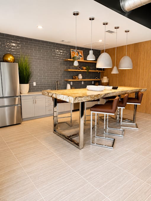 Resident clubroom at 200 Main Kannapolis featuring a modern kitchen, communal dining table, and stylish gathering space.