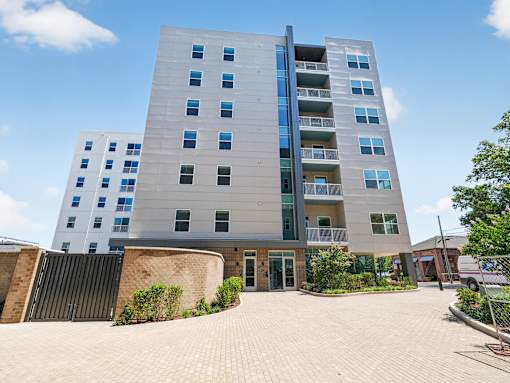 A modern multi-story building with a mix of blue and grey balconies.