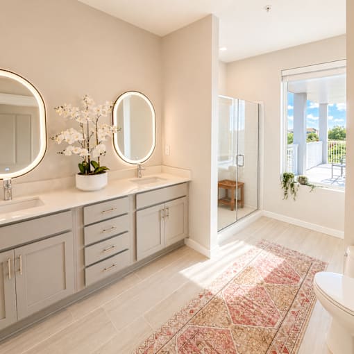 Luxury apartment bathroom at 200 Main Kannapolis with double vanity, modern lighting, quartz countertops, and walk-in shower.