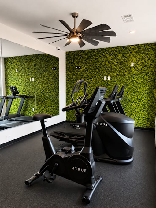 State-of-the-art fitness center featuring cardio equipment, mirrored walls, designer finishes, and a living green wall at 200 Main Kannapolis.