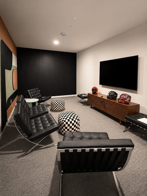 Resident lounge and game room with designer seating, large flat-screen TV, modern furnishings, and contemporary décor at 200 Main Kannapolis.