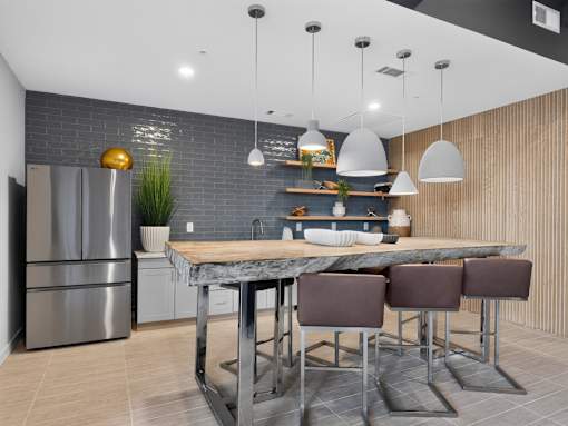 A modern kitchen with a marble table and stainless steel appliances.