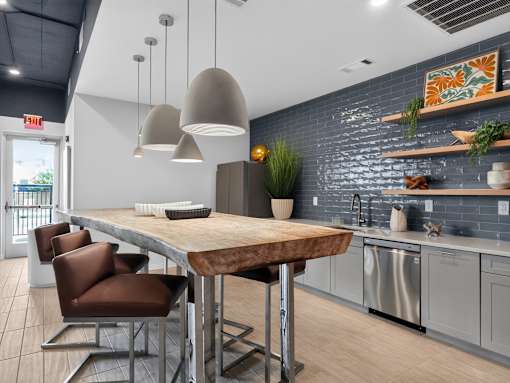 A modern kitchen with a wooden table and brown chairs.