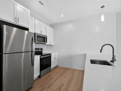 A modern kitchen with stainless steel appliances and white cabinetry.