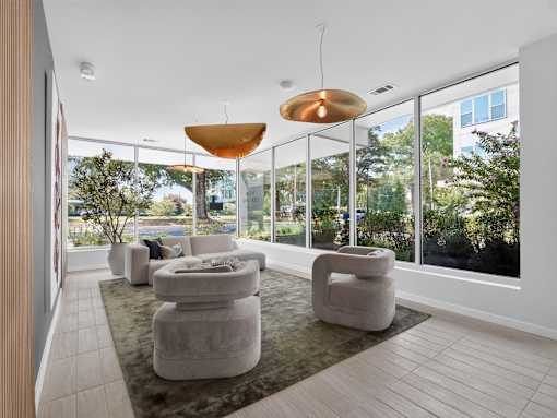 A modern living room with a large window and a grey sofa.