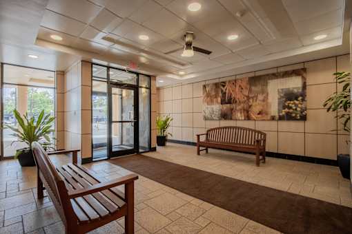 a lobby with benches and a painting on the wall