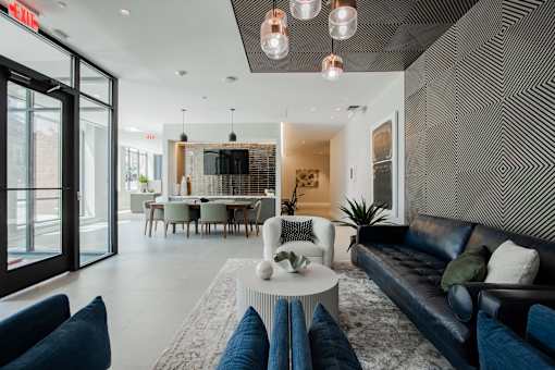 Elegant lobby area with bold accent wall, artistic lighting, and comfortable seating—modern design meets comfort at The Rail Bound Brook.