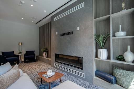Cozy lounge nook with modern fireplace and built-in shelving inside The Rail at Bound Brook’s game room.