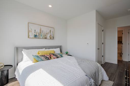 Interior bedroom photo from The Rail at Bound Brook showcasing high-end finishes, a walk-in closet, and modern apartment design near commuter-friendly transit access.