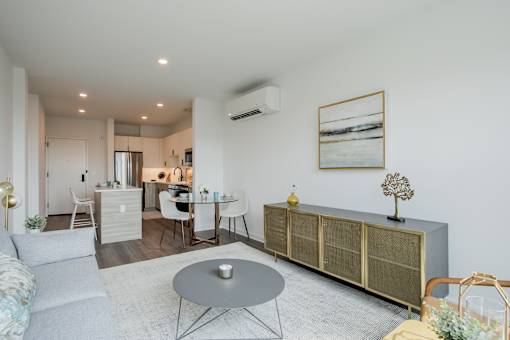 Contemporary kitchen at The Rail featuring white cabinetry, subway tile backsplash, stainless steel appliances, and natural light from large windows.