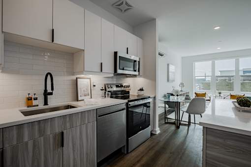 Spacious kitchen and dining space in a luxury Bound Brook apartment with sleek finishes, breakfast island seating, and bright natural lighting.