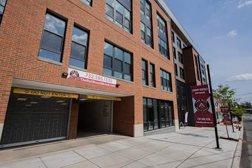 Street-level image of The Rail at Bound Brook luxury apartments with visible garage entrance.