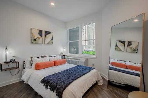 Spacious bedroom in a modern Bound Brook apartment featuring large windows at The Rail at Red Bank, NJ.