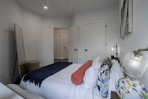 Interior of a luxury bedroom with modern lighting and closet access in a pet-friendly apartment near downtown Bound Brook.