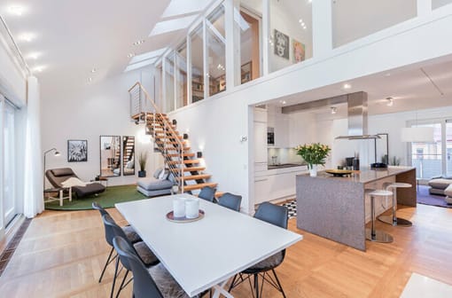 a living room and dining room with a staircase in a house