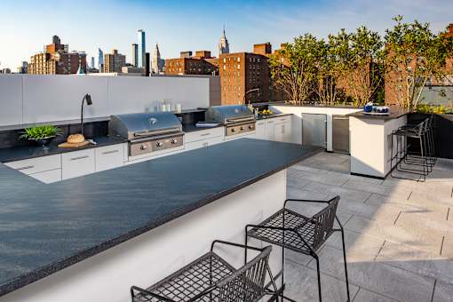 a kitchen and dining area on a roof with a city skyline in the background