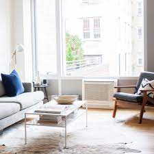 a living room with a couch coffee table and a kitchen with a breakfast bar