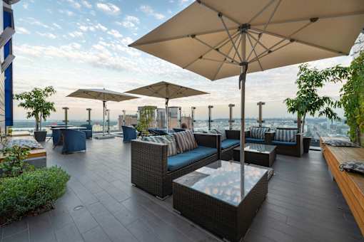 A patio with a table and chairs under a large umbrella.