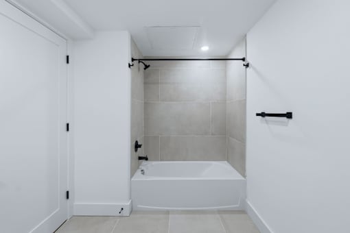 A white bathroom with a tub and a shower.