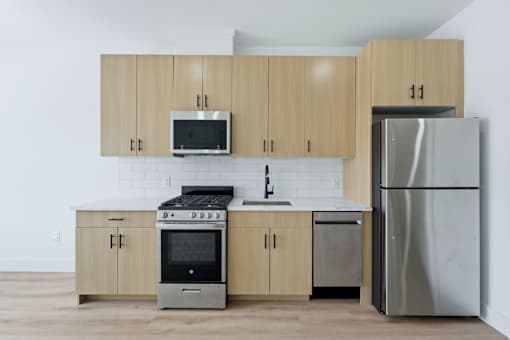A kitchen with a stove, oven, refrigerator, and microwave.