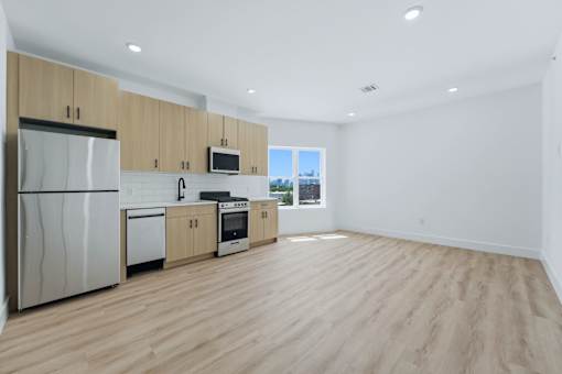 A kitchen with wooden floors and white walls.