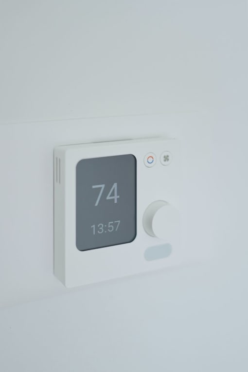 A white thermostat shows the temperature as 74 degrees and the time as 13:57.
