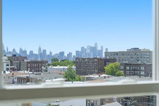 A cityscape with buildings of various heights and a clear blue sky.