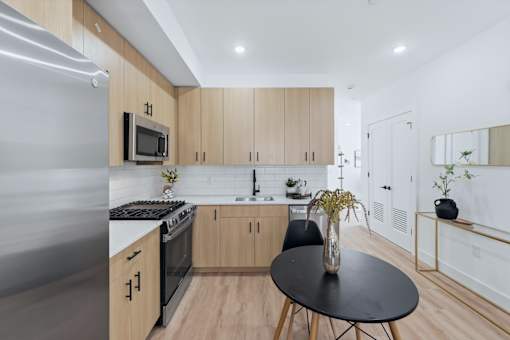 A modern kitchen with wooden cabinets and a black table.