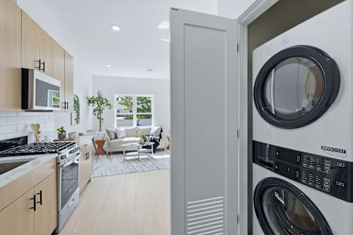 A modern kitchen with a washing machine in the foreground.