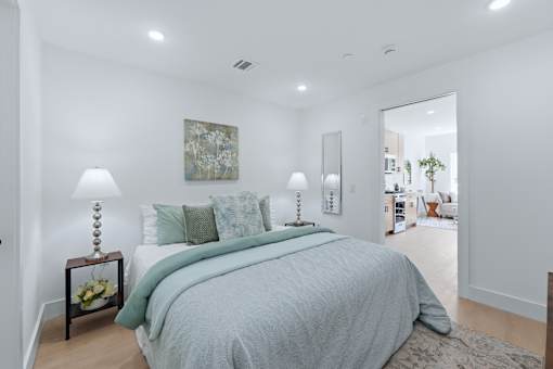 A bedroom with a large bed and a painting on the wall.