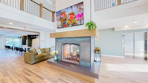 A living room with a fireplace and a painting above it.