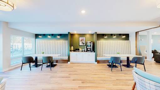 A room with a white counter and blue chairs.