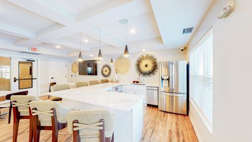 A kitchen with a white island and wooden floors.