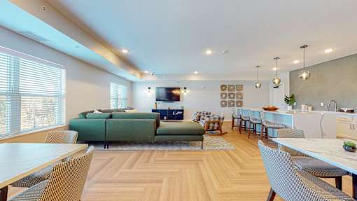 A modern living room with a green sofa and wooden floors.