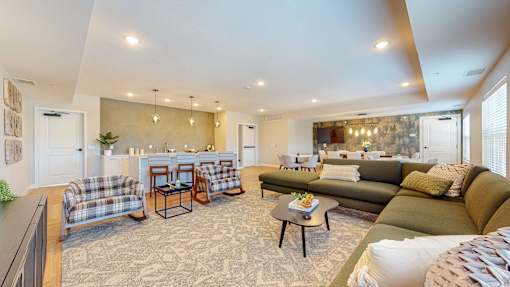 A living room with a couch, chairs, and a coffee table.