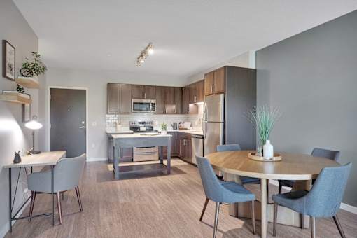 A modern kitchen with a dining table and chairs.