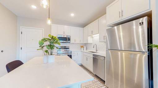 A modern kitchen with a large island and stainless steel appliances.