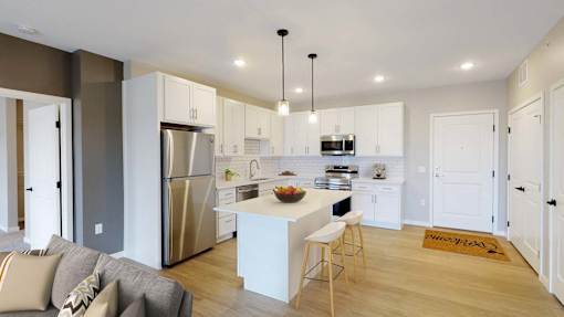 A modern kitchen with a refrigerator, stove, and sink.
