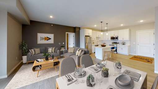 A modern dining room with a wooden table set for two.
