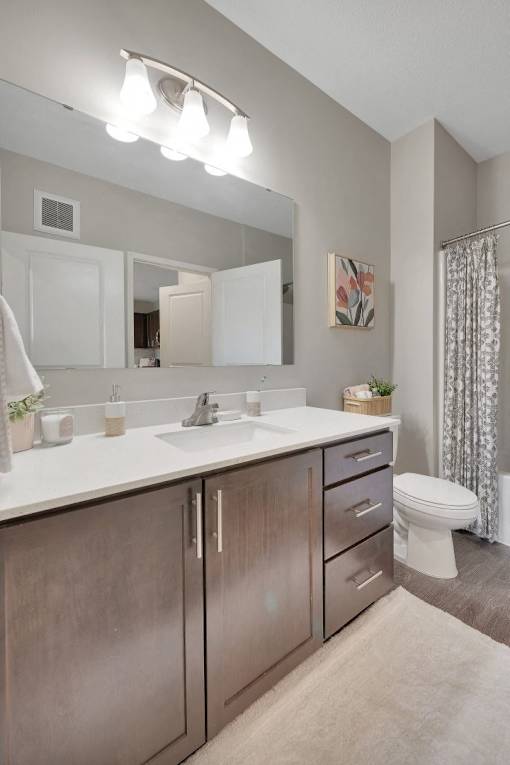 A bathroom with a white countertop and a white toilet.