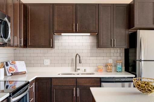 A kitchen with brown cabinets and a white countertop.