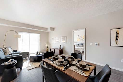 A modern dining room with a wooden table set for four.