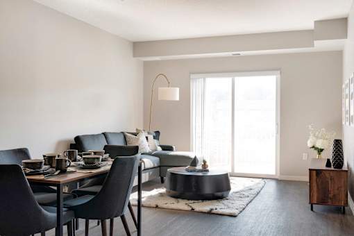 A modern dining room with a black table and chairs.