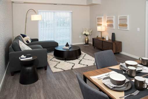 A modern living room with a dining table set for two.