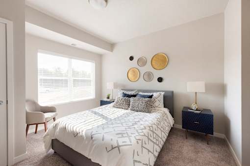 A bedroom with a bed, chair, and wall decor.