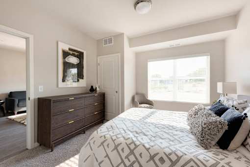 A bedroom with a large bed and a dresser.