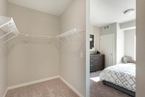 A bedroom with a white bed and a white closet.