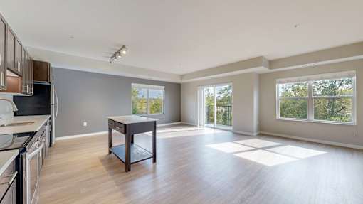 A spacious kitchen and dining area with wooden floors and large windows.