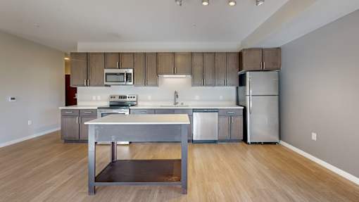 A kitchen with a stainless steel refrigerator and a wooden island.