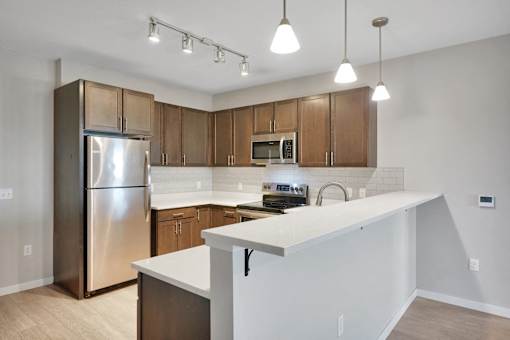 A kitchen with a white counter and wooden cabinets.